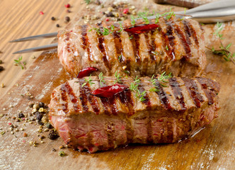 Grilled Beef steak on   wooden cutting board .