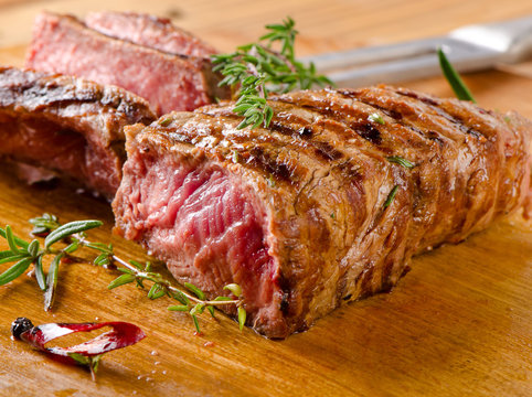 Grilled  steak on a  wooden cutting board .