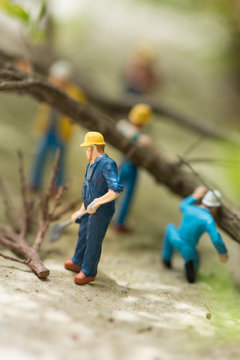 Miniature workers clearing fallen trees