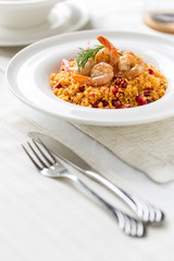 couscous with prepared shrimps and dill in white plate