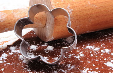 Cookie cutters and rolling pin on dough for gingerbread