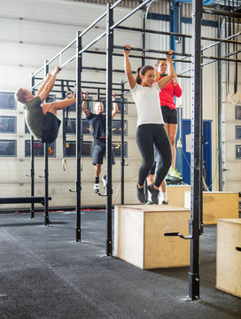 Athletes Exercising On Gymnastic Bars