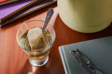A moment of relax drinking a glass of hot tea or other herbal infusion, while reading books