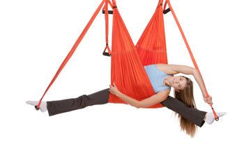 Young woman making aerial yoga exercises in stretching