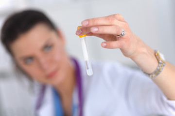 Woman researcher is surrounded by medical vials and flasks,