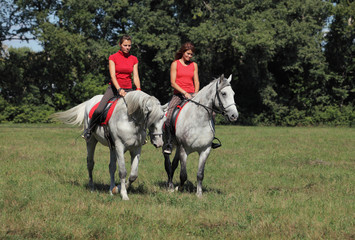 Two romantic female riding a horse outdoors