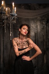 Tattooed beautiful woman in old spooky interior