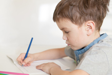 Serious pensive pupil sits at desk