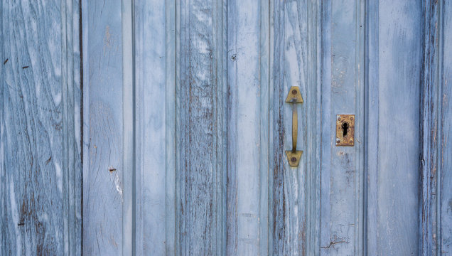 Old blue run-down wooden door and lock
