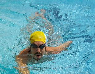Fototapeta na wymiar portrait swimmer beautiful boy swims in pool crawl