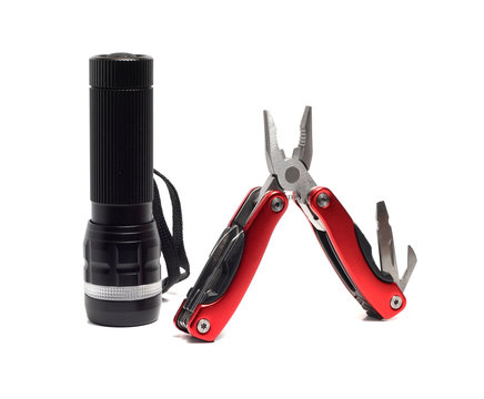 flashlight and multi tools on a white background
