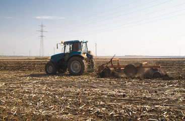 Farmer in tractor preparing land for sowing