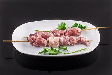Raw skewer and vegetables on plate