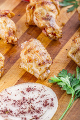 grilled chicken wings and legs on wooden plate