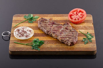 Grilled Steaks and Vegetables On a Wood Plate