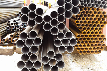 heap of metal pipes in outdoor warehouse