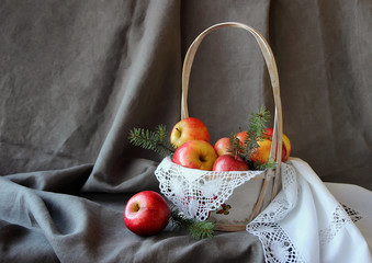 Still life with a basket of apples on white napkin.