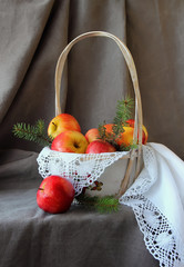 Still life with a basket of apples on white napkin.