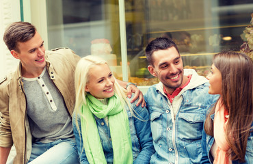 group of smiling friends walking in the city