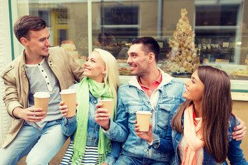 group of smiling friends with take away coffee
