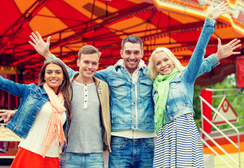 group of smiling friends waving hands