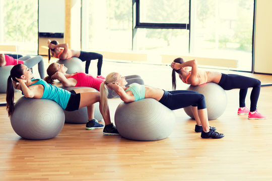 Group Of Smiling Women With Exercise Balls In Gym