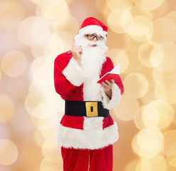 man in costume of santa claus with notepad