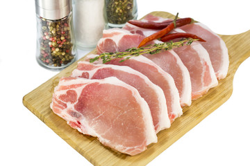 raw pork steaks on a cutting board