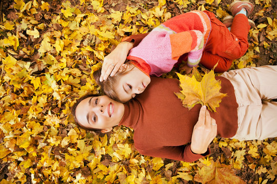 Mother and little daughter enjoying autumn day in a park
