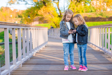 Fototapeta premium Adorable little girls at warm autumn day outdoors