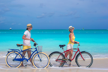 Fototapeta premium Happy couple riding bikes during tropical vacation