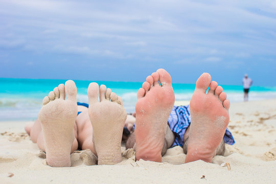 Closeup male and female feet on white sand