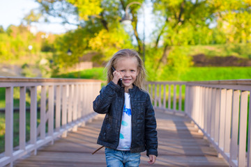 Adorable little girl at warm autumn day outdoors