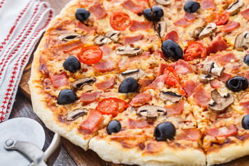 Pizza with ham, mushrooms and olives