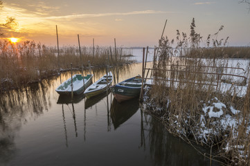 łódki zacumowane zimą do drewnianego pomostu