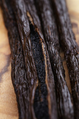 open vanilla pod on olive board