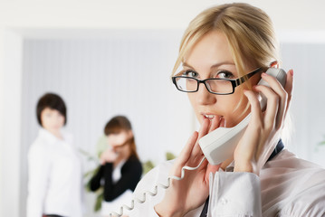 Attractive woman calls by wire phone in office