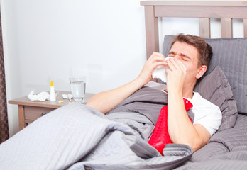 mann mit grippe im bett
