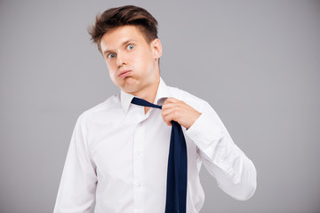Tired man loosening his tie