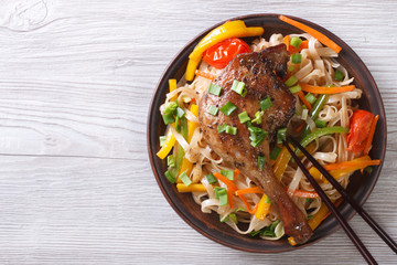 Rice noodles with duck leg and vegetables horizontal, top view