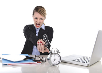 angry businesswoman working pointing gun to alarm clock