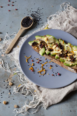 wholemeal vegan toast with avocado slices and seeds on plate