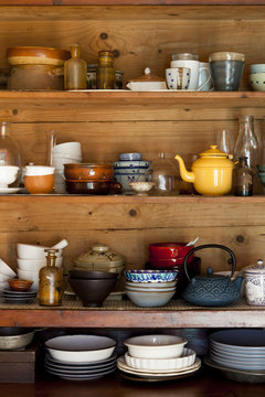 ceramics and kitchen equipment on rustic wooden shelves