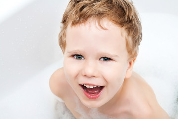 Cute kid taking bath with foam