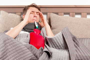 mann mit grippe im bett