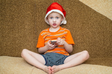 Boy using his smartphone while seated in front of the Christmas