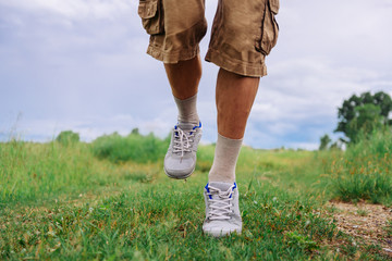 Unrecognizable man running on footpath in summer