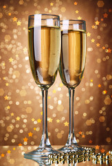 Glasses of champagne on bright background