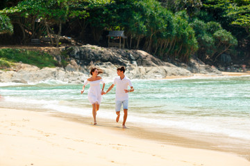 Fototapeta na wymiar happy couple running on tropical beach