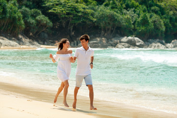 happy couple running on tropical beach